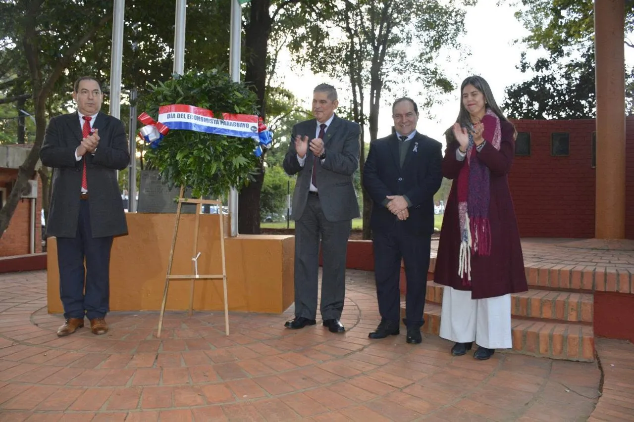 Ofrenda floral con la cinta «Día del Economista Paraguayo», acompañada por cuatro autoridades