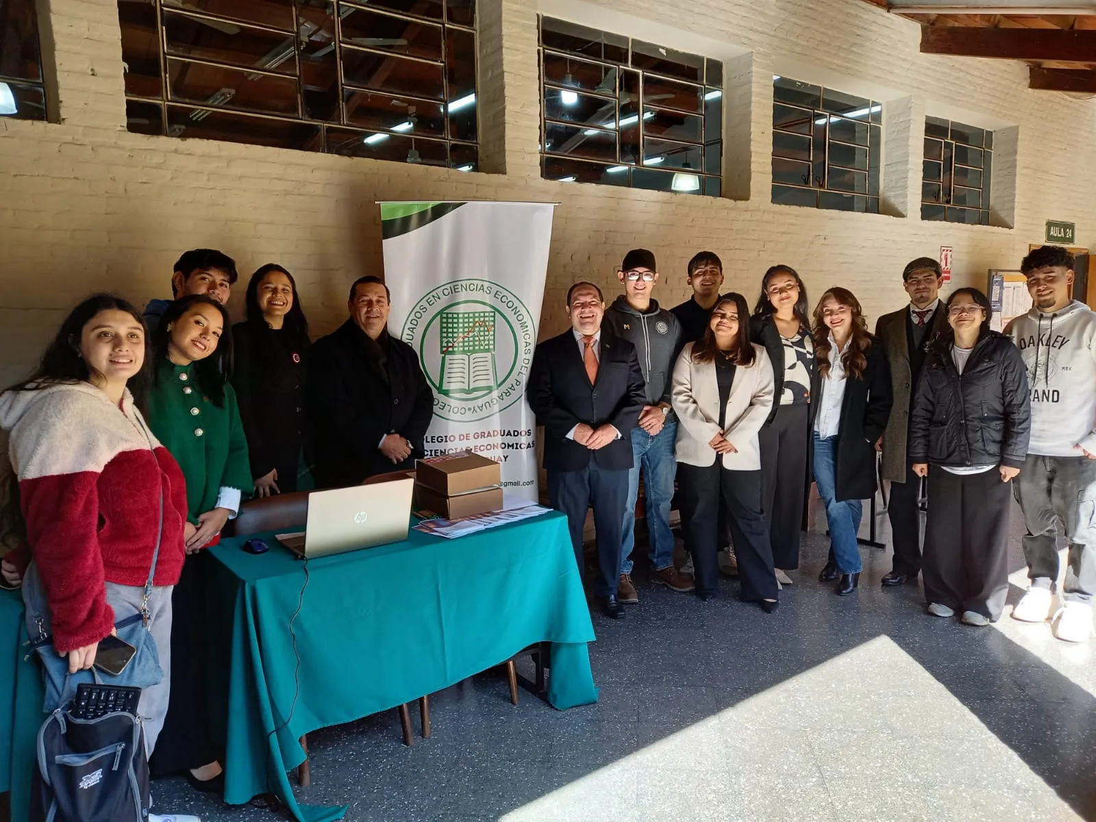 Estudiantes y miembros del Colegio junto al stand institucional montado en la Facultad